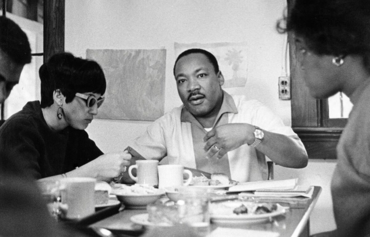 Dr Martin Luther King Jr talking to group during meal