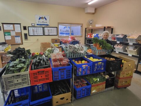 person stands next to bin of carrots in Ocean Shores Food Bank